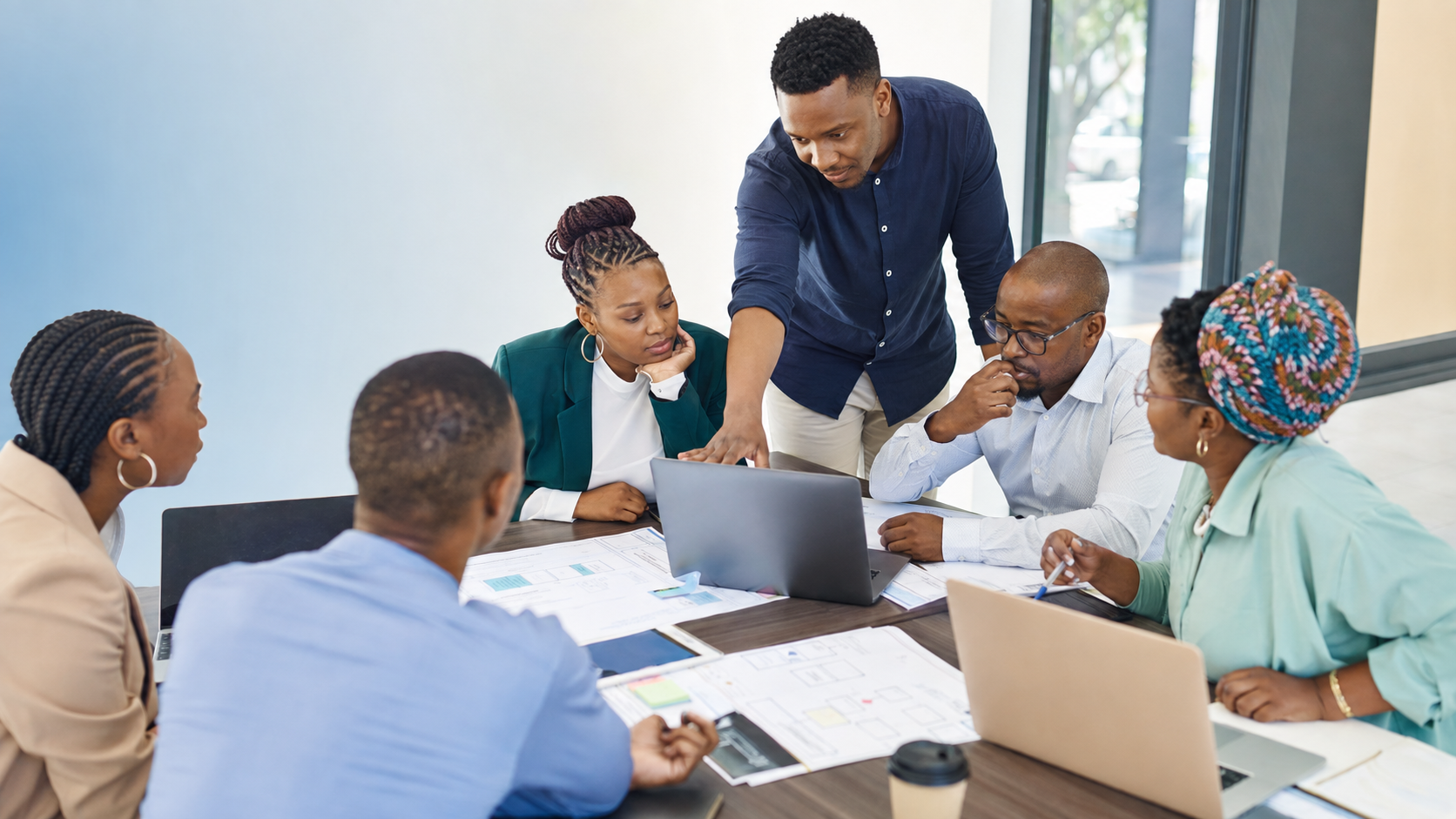 African business team collaborating around digital systems